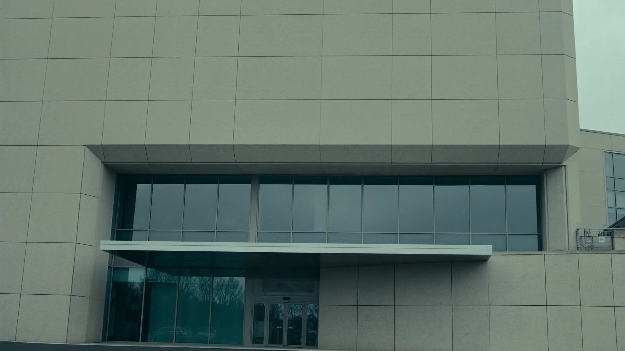 Modern regulated-facility exterior under an overcast sky